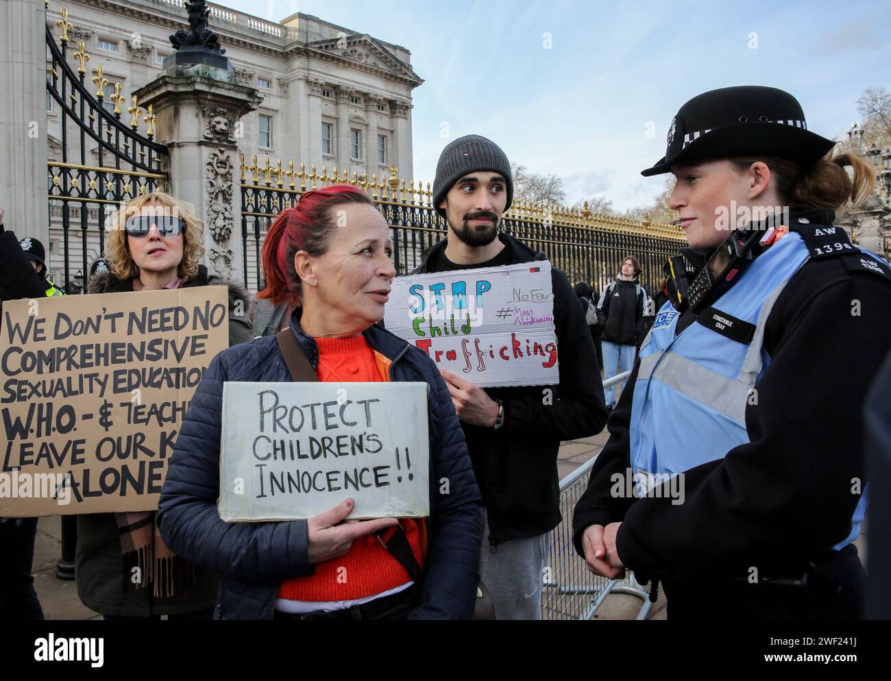 Londra, Regno Unito. 27 gennaio 2024. I manifestanti tengono cartelli a favore di salvare i bambini dagli abusi mentre parlano con un agente di polizia. Un gruppo di manifestanti si è riunito per manifestare contro coloro che sono al governo e posizioni di potere che credono stiano permettendo la sessualizzazione dei bambini nei programmi scolastici, la vaccinazione COVID-19 dei bambini, l'abuso rituale satanico, il traffico di minori e l'uso di adrenocromo. Richiedono risposte e un'indagine adeguata che renderà responsabili tutti i detentori del potere. Credito: SOPA Images Limited/Alamy Live News Foto Stock