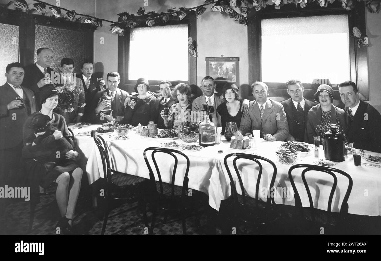 Una folla di giovani adulti si affollano attorno a un tavolo da banchetto a Chicago, California. 1928. Foto Stock