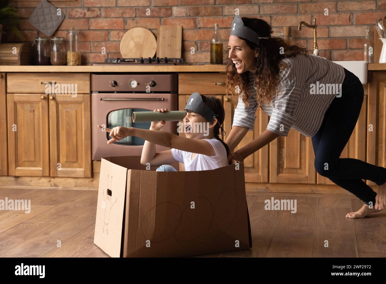 Ridendo la giovane madre latina si diverte a fingere pirati con una figlia piccola Foto Stock