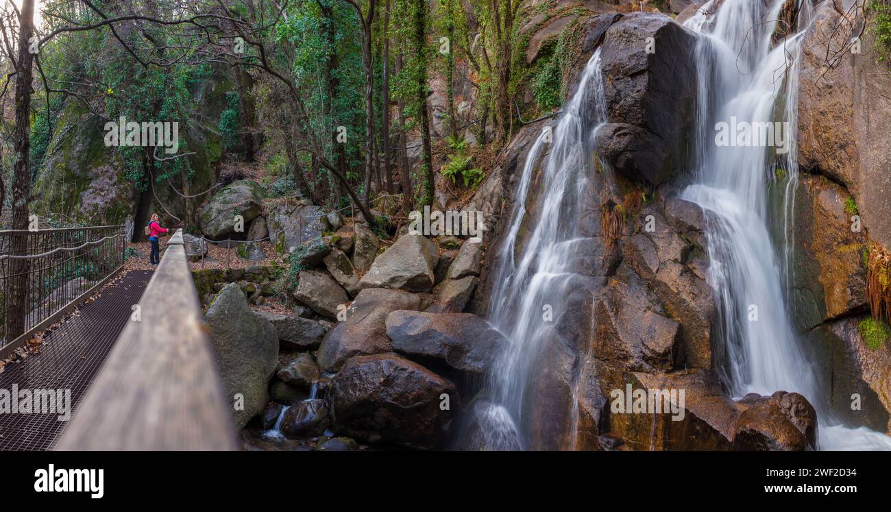 Donna visitatrice che osserva la cascata di Nogaleas dal ponte pedonale. Jerte Valley, Navaconcejo, Caceres, Spagna Foto Stock