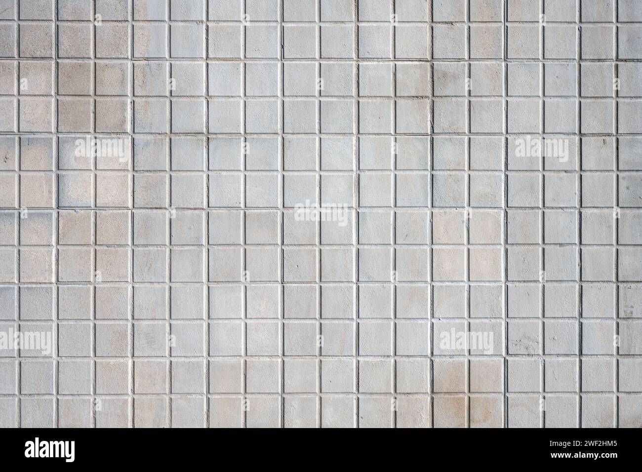 Sfondo da una parete fatta di tessere mosaico quadrate beige Foto Stock