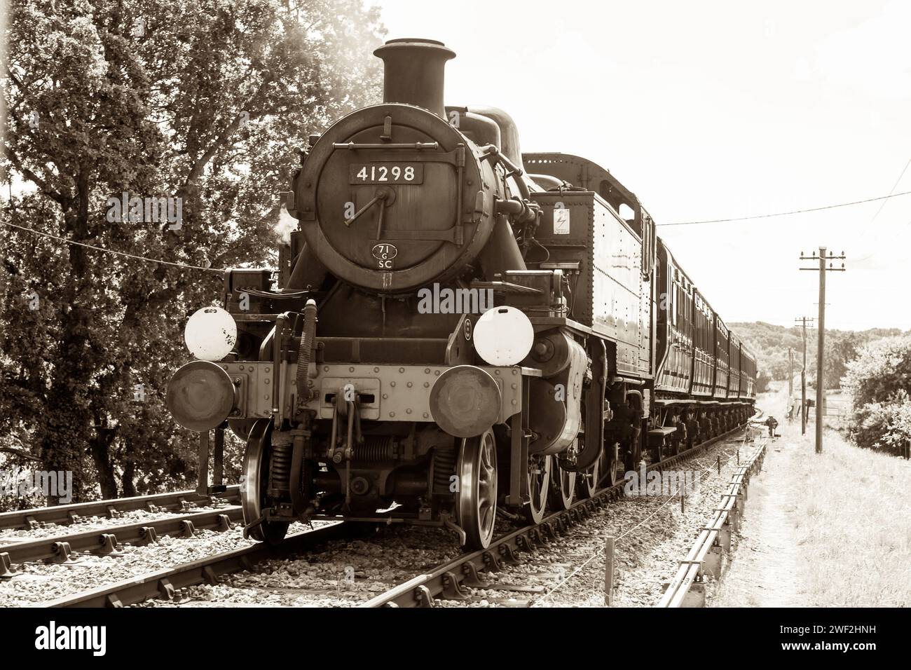 Il motore cisterna Ivatt Classe 2, 41298 trasporta un treno nella stazione di Wootton sulla ferrovia a vapore dell'Isola di Wight, Inghilterra, Regno Unito: Tonalità seppia d'epoca. Foto Stock