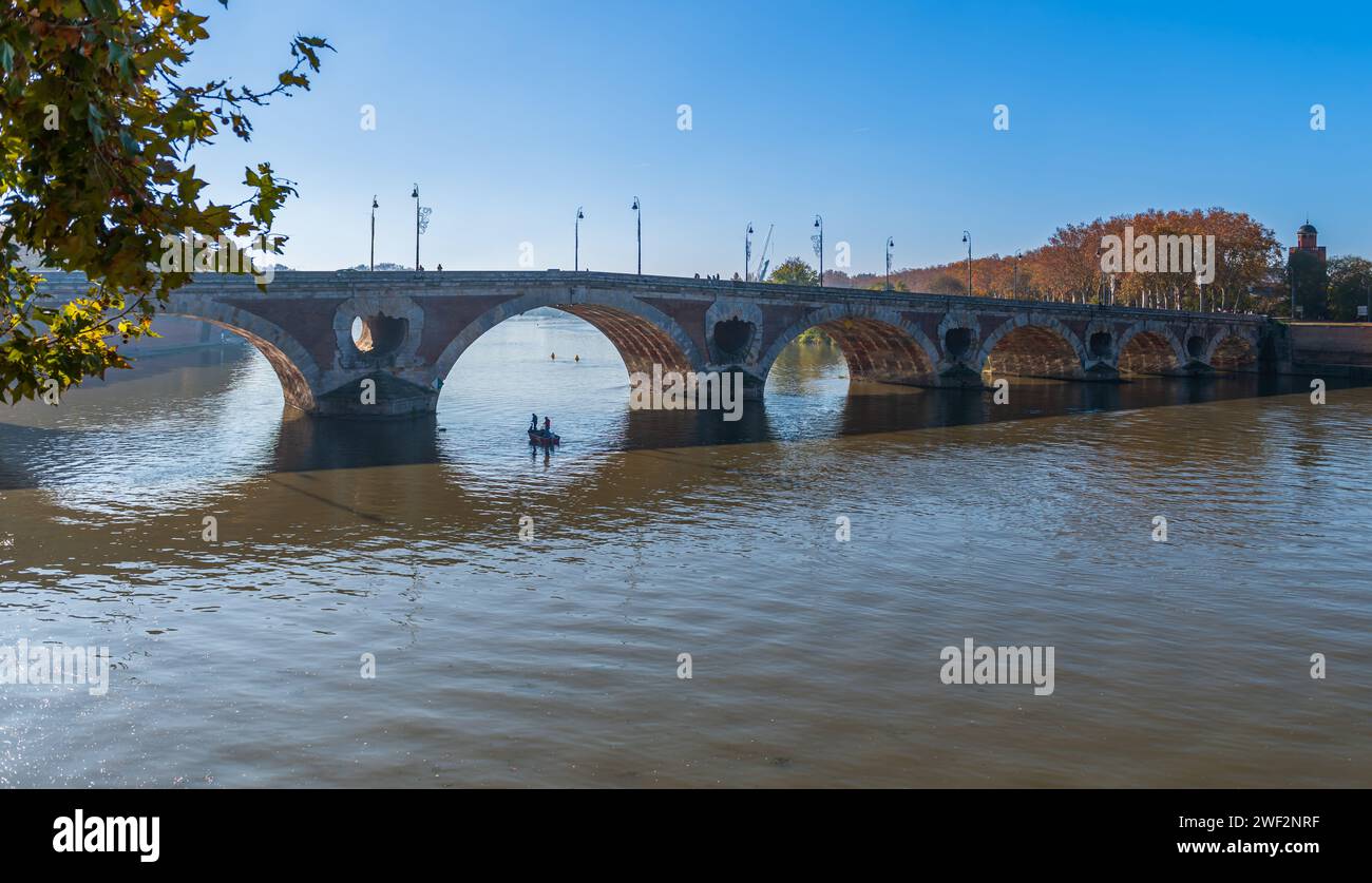 Due pescatori in una barca nell'arco del Pont Neuf sopra la Garonna, a Tolosa, Occitanie, Francia Foto Stock