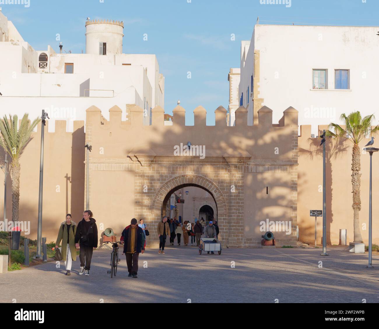 Persone a Bab (porta) Sbaa, una delle porte d'ingresso principali della storica Medina nella città di Essaouira, Marocco, 28 gennaio 2024 Foto Stock