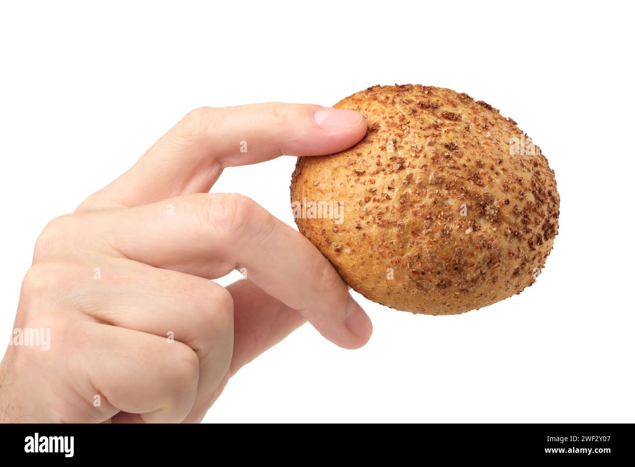 Mano umana che tiene un piccolo panino tondo di grano, vista laterale, isolato su sfondo bianco Foto Stock