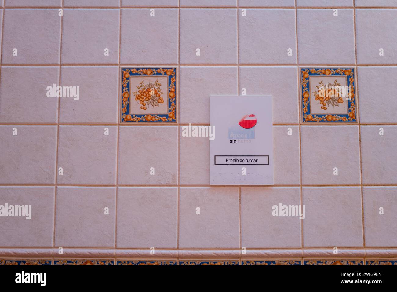 Cartello per non fumatori su una parete piastrellata di ceramica all'interno del mercato interno di pesce fresco al mercato di Los Christianos sull'isola delle Canarie di Tenerife. Foto Stock