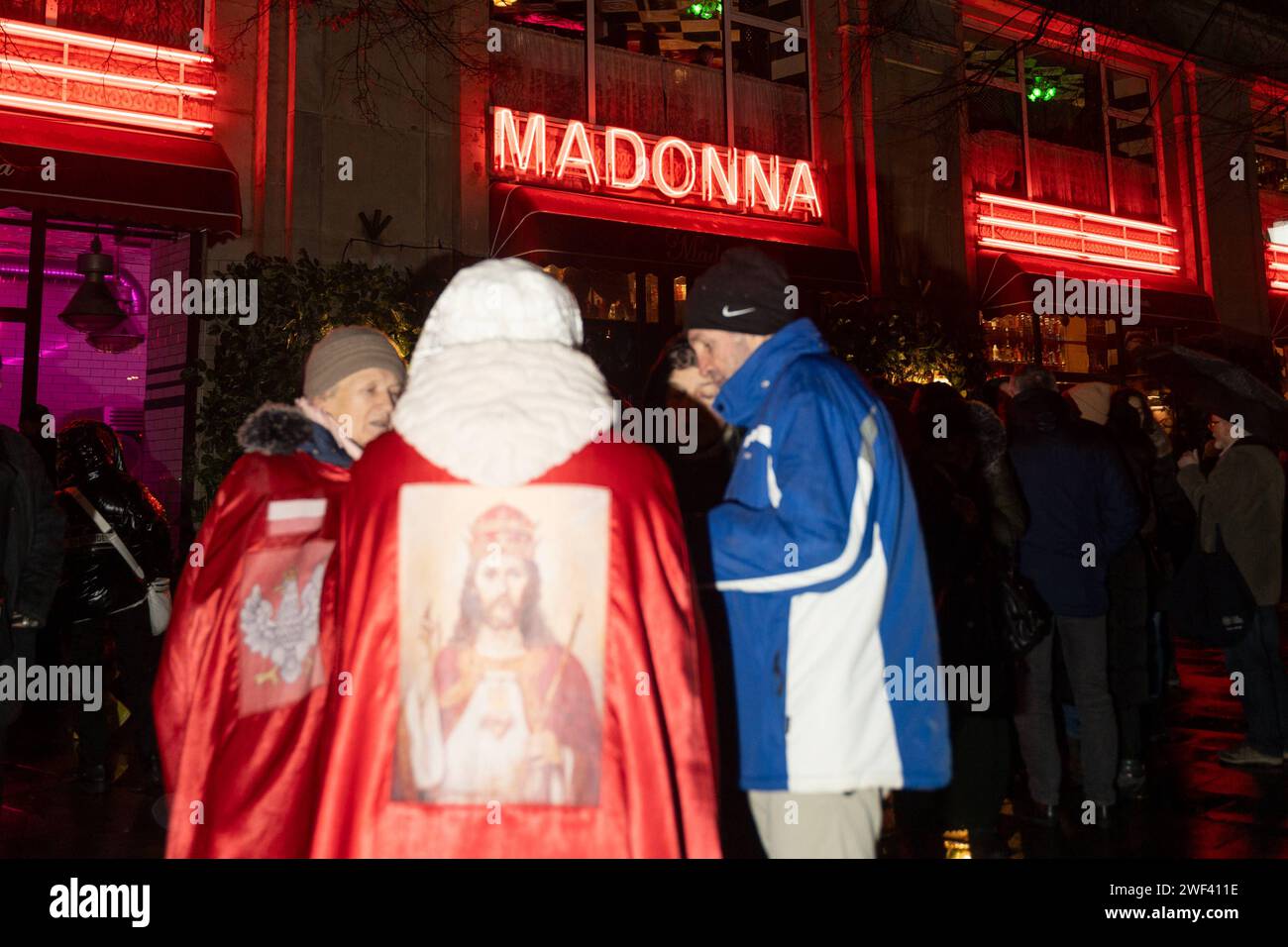 Il dimostratore vestito con un cappotto rosso con l'immagine di Gesù si trova di fronte al ristorante Madonna, che secondo molte persone offende i cristiani. La protesta prega per il rinnovamento morale della Polonia di fronte al ristorante Madonna a Varsavia il 27 gennaio 2024. Decine di persone si sono riunite per chiedere la chiusura del ristorante del Rosario pubblico di Madonna per il rinnovamento morale della Polonia Copyright: XMarekxAntonixIwanczukx MAI03765 Foto Stock
