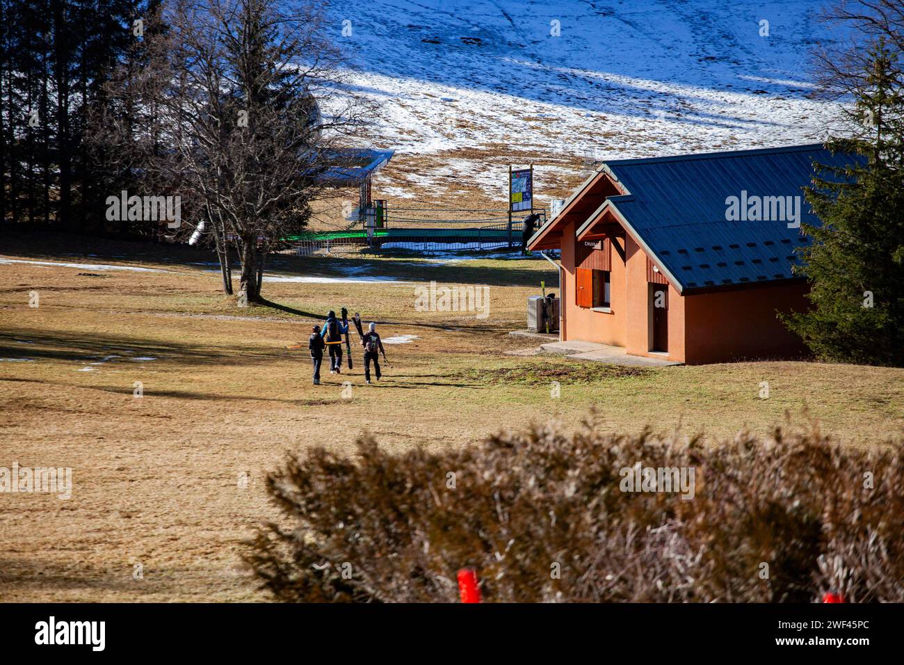 Villard De Lans, Francia. 28 gennaio 2024. Gli sciatori devono attraversare l'erba per accedere alla partenza della seggiovia Glovettes, la stazione sciistica di Villard de Lans manca di neve mentre le vacanze di febbraio si avvicinano, Francia, Isere, Villard de Lans, il 27 gennaio, 2024. foto di Thibaut Durand/ABACAPRESS.COM Credit: abaca Press/Alamy Live News Foto Stock