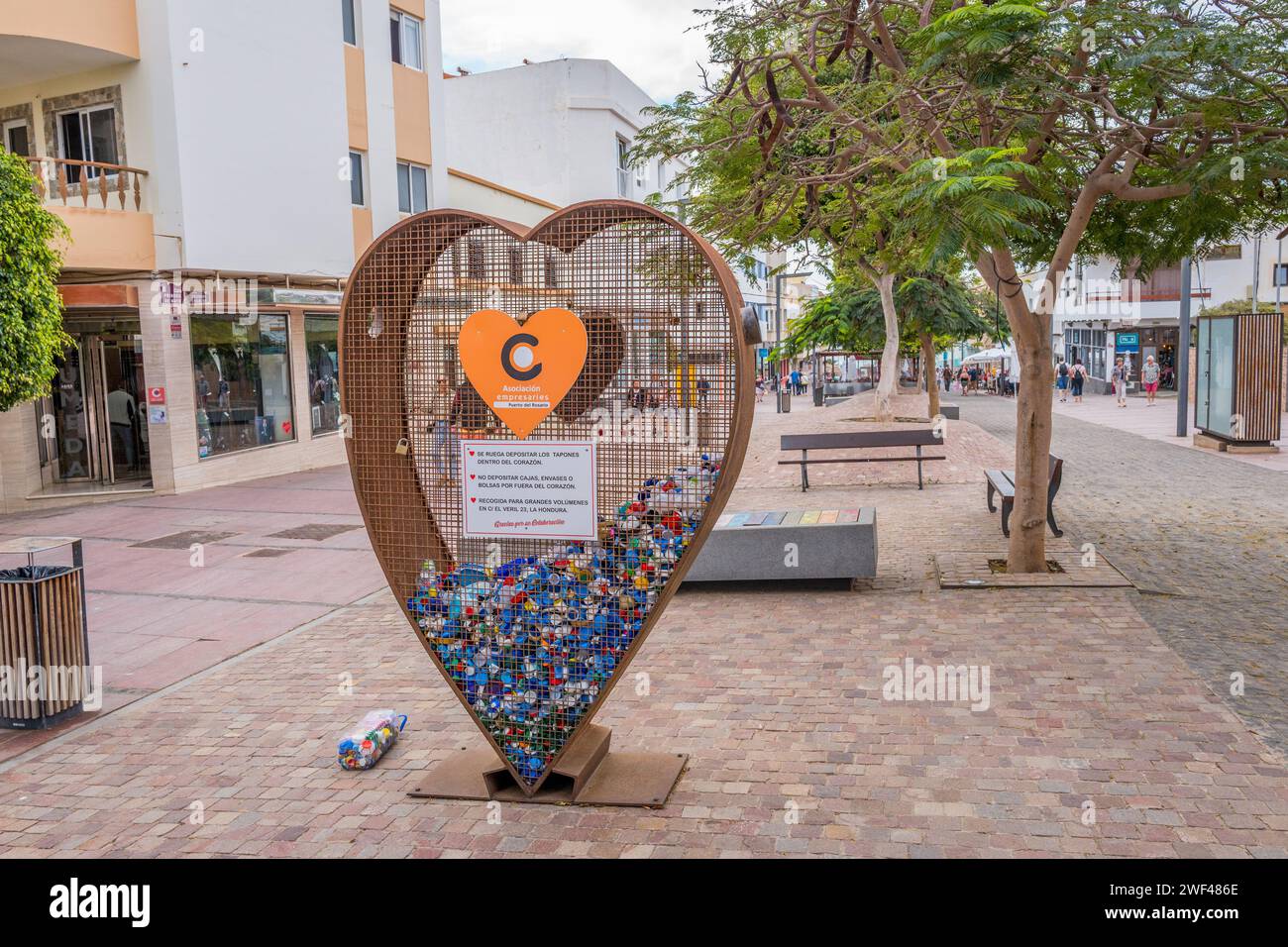 Ampia selezione di bottiglie di plastica colorata in una zona a gabbia a forma di cuore. Foto Stock