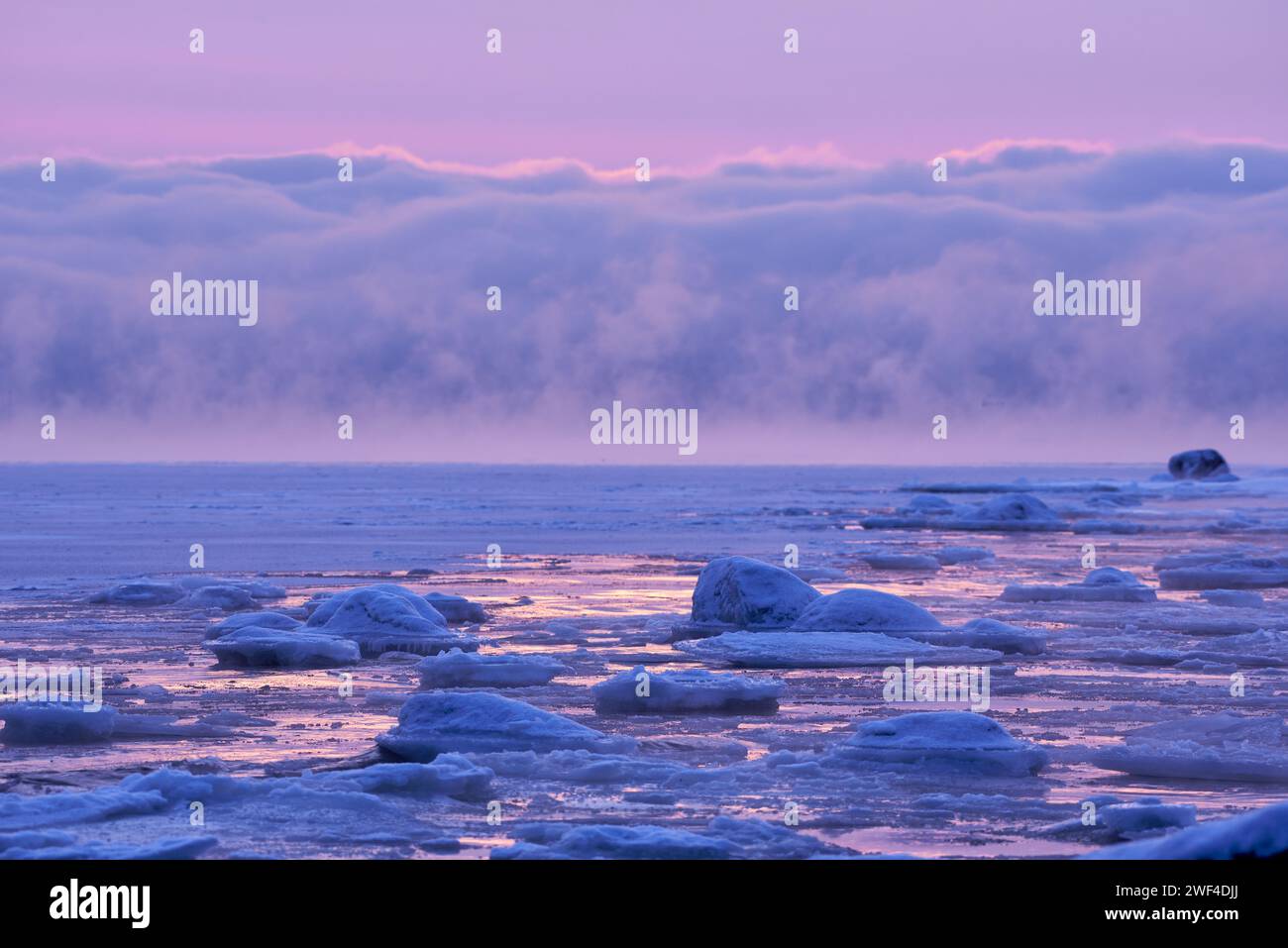 Paesaggio marino invernale ghiacciato con fumo di mare in lontananza a Helsinki, Finlandia. Foto Stock