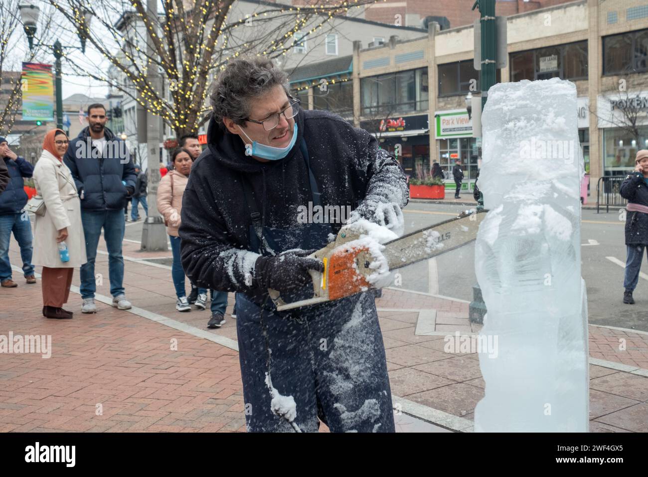 Jimmy Chiappe, scultore del ghiaccio, scolpisce un gorilla da blocchi di ghiaccio utilizzando una motosega. Al Fire Ice Festival al Columbus Park di Stamford, Connecticut. Foto Stock