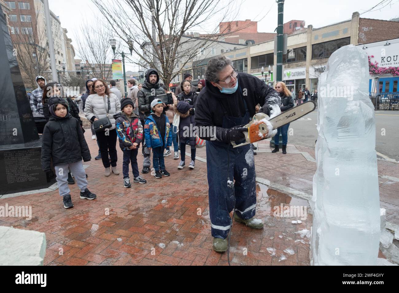 Jimmy Chiappa, scultore di ghiaccio, scolpisce un gorilla da blocchi di ghiaccio usando una motosega. Al Fire Ice Festival al Columbus Park di Stamford, Connecticut Foto Stock