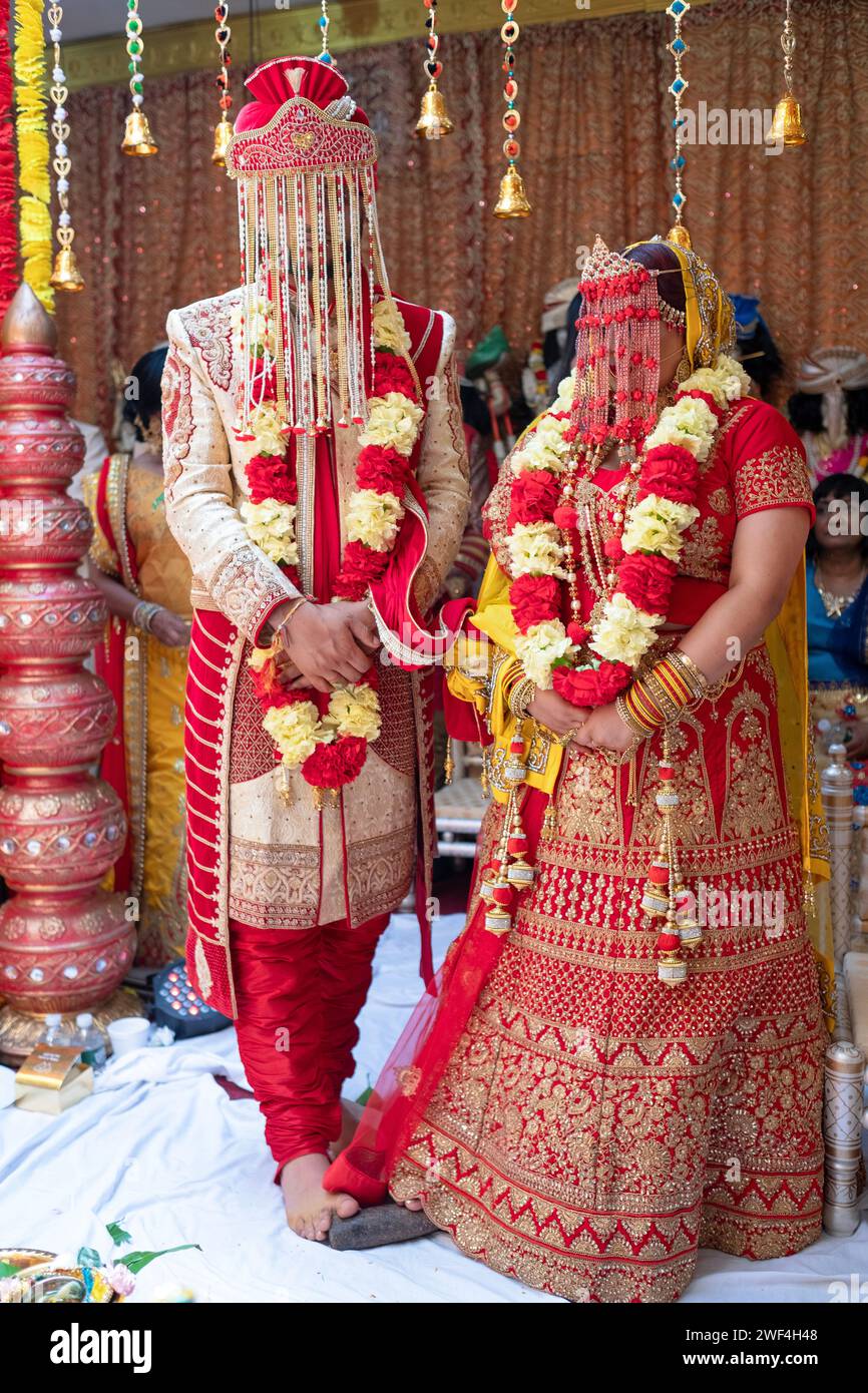 Uno sposo indù in abiti tradizionali si erge su una pietra come parte della cerimonia nuziale. Tempio in e Shakti nel Queens, New York. Foto Stock
