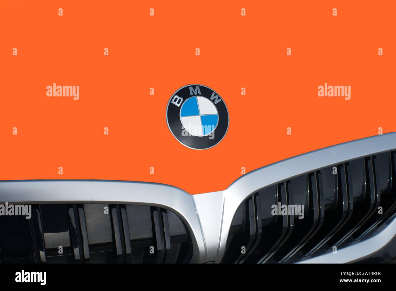 OCALA, FLORIDA - 2 NOVEMBRE 2023 emblema del logo BMW bruciato sul cofano dell'auto arancione. Bavaria Motor Works multinazionale tedesca produttrice di veicoli di lusso Foto Stock