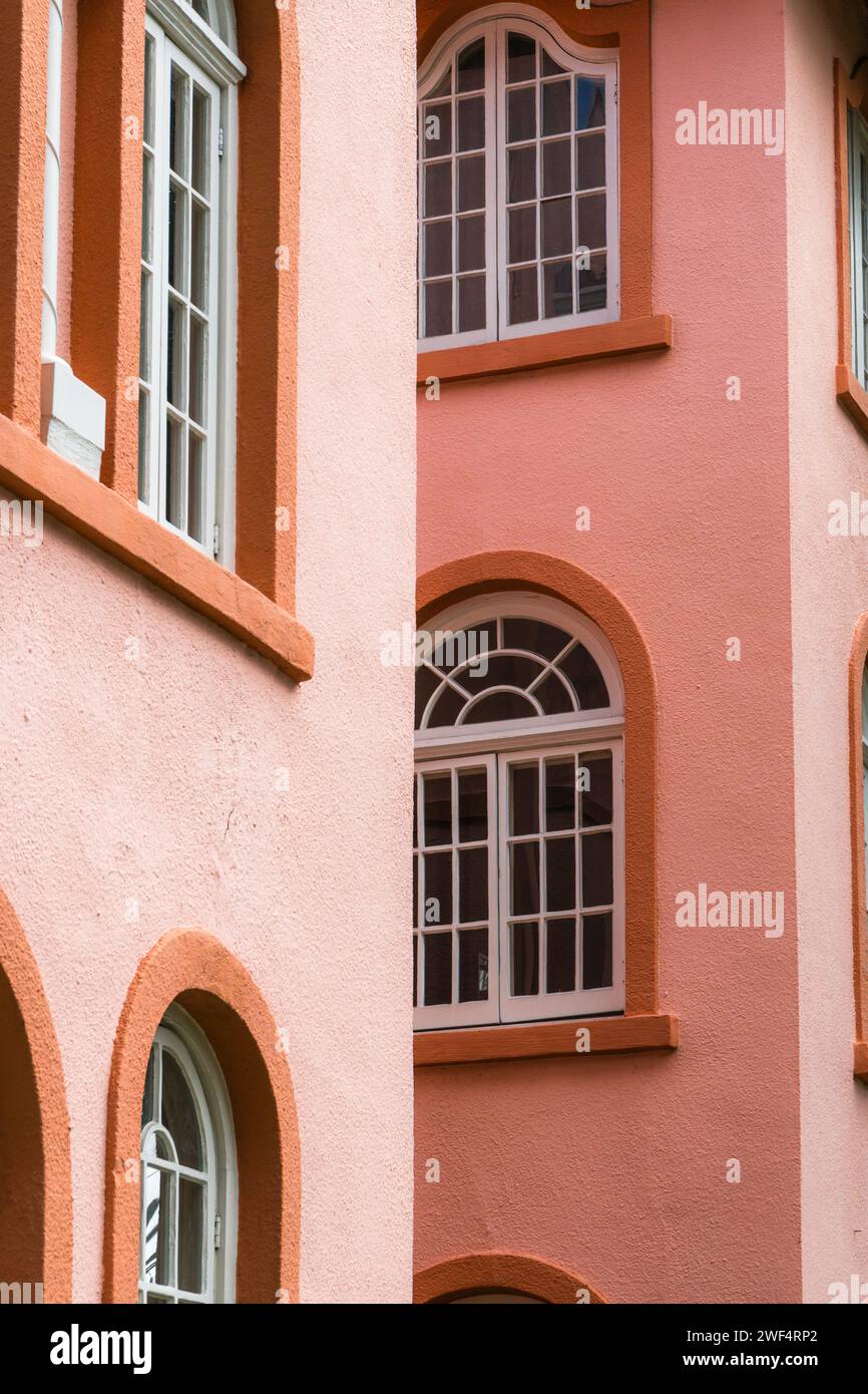 Edificio d'epoca color pesca con esterni con finestre e porte ad arco nel colore del pesco fuzz. Foto Stock