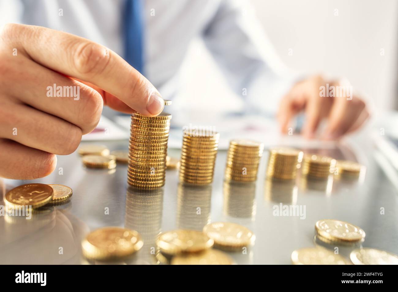 Simbolo del profitto crescente, un uomo d'affari forma un grafico crescente con una moneta in euro. Foto Stock