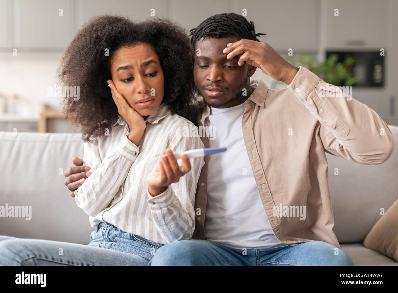 Gli sposi neri preoccupati sono turbati da risultati positivi del test di gravidanza in interni Foto Stock