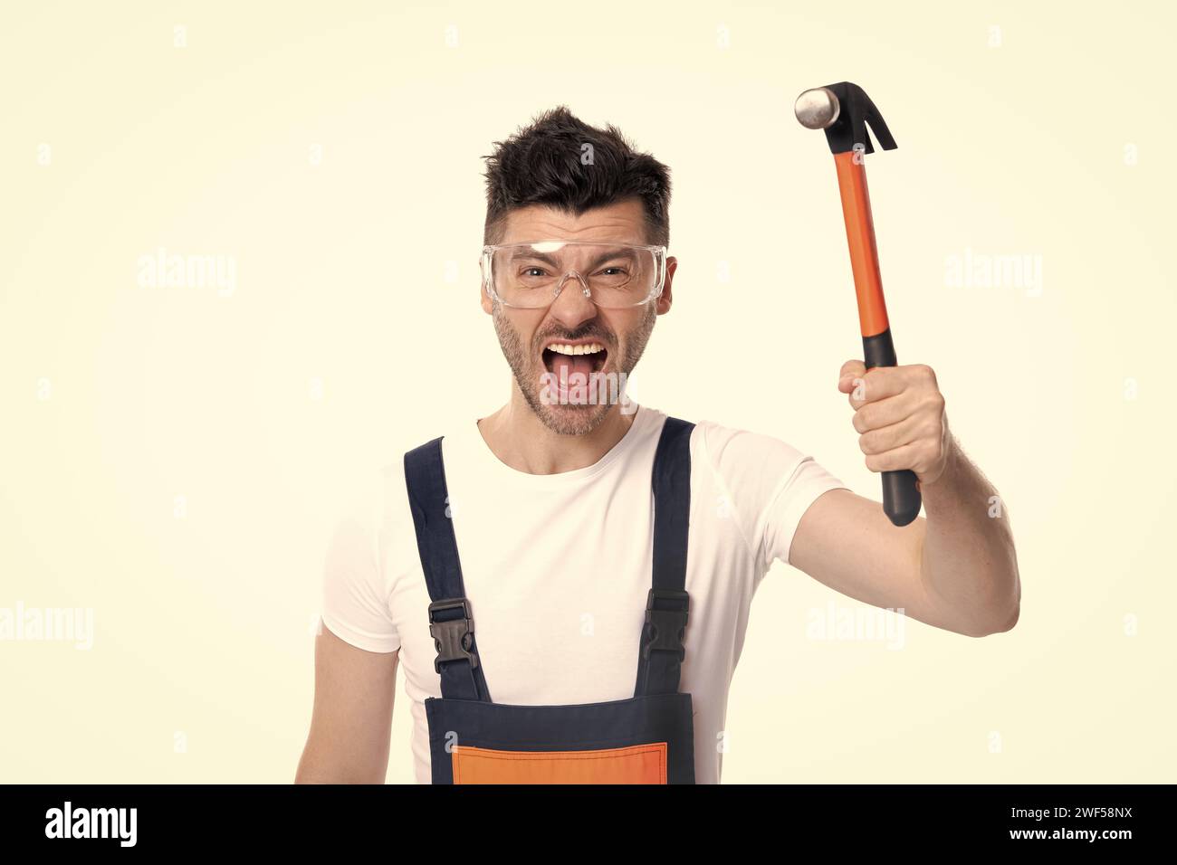 caposquadra arrabbiato tenere martello isolato su sfondo bianco. occupazione caposquadra Foto Stock