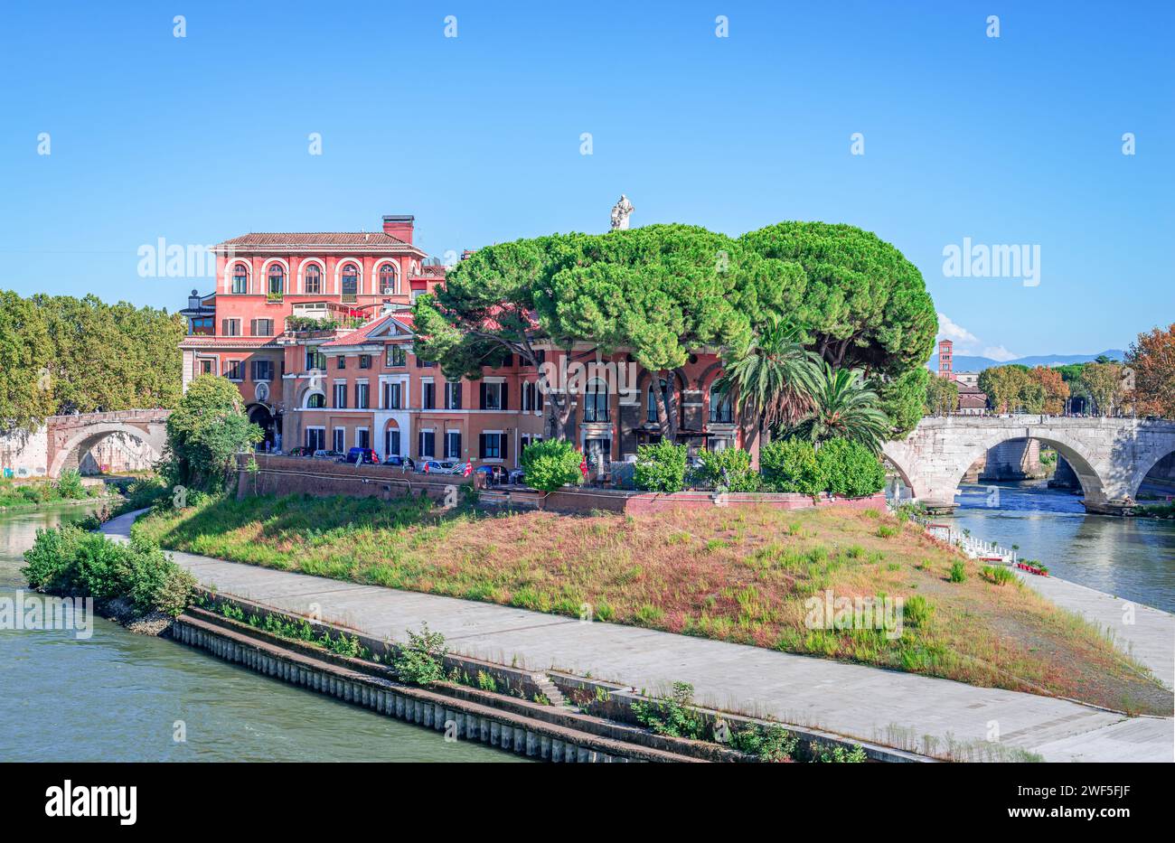 Isola Tevere a Roma, Italia con l'ospedale Fatebenefratelli e Ponte Cestio sulla destra, un antico ponte romano in pietra. Foto Stock