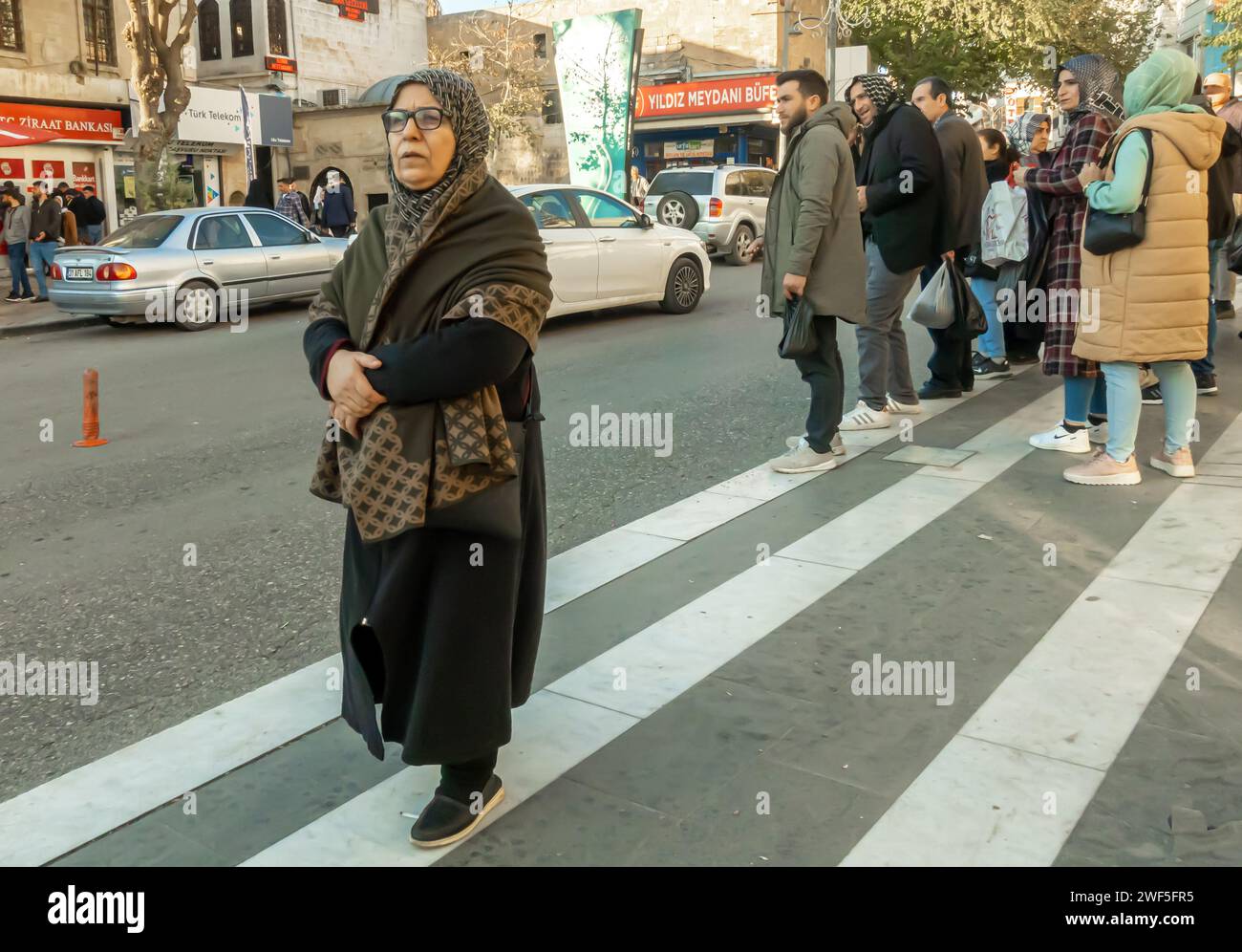 Gente di Sanliurfa in attesa di un autobus nella strada centrale di Sanliurfa in Turchia Foto Stock