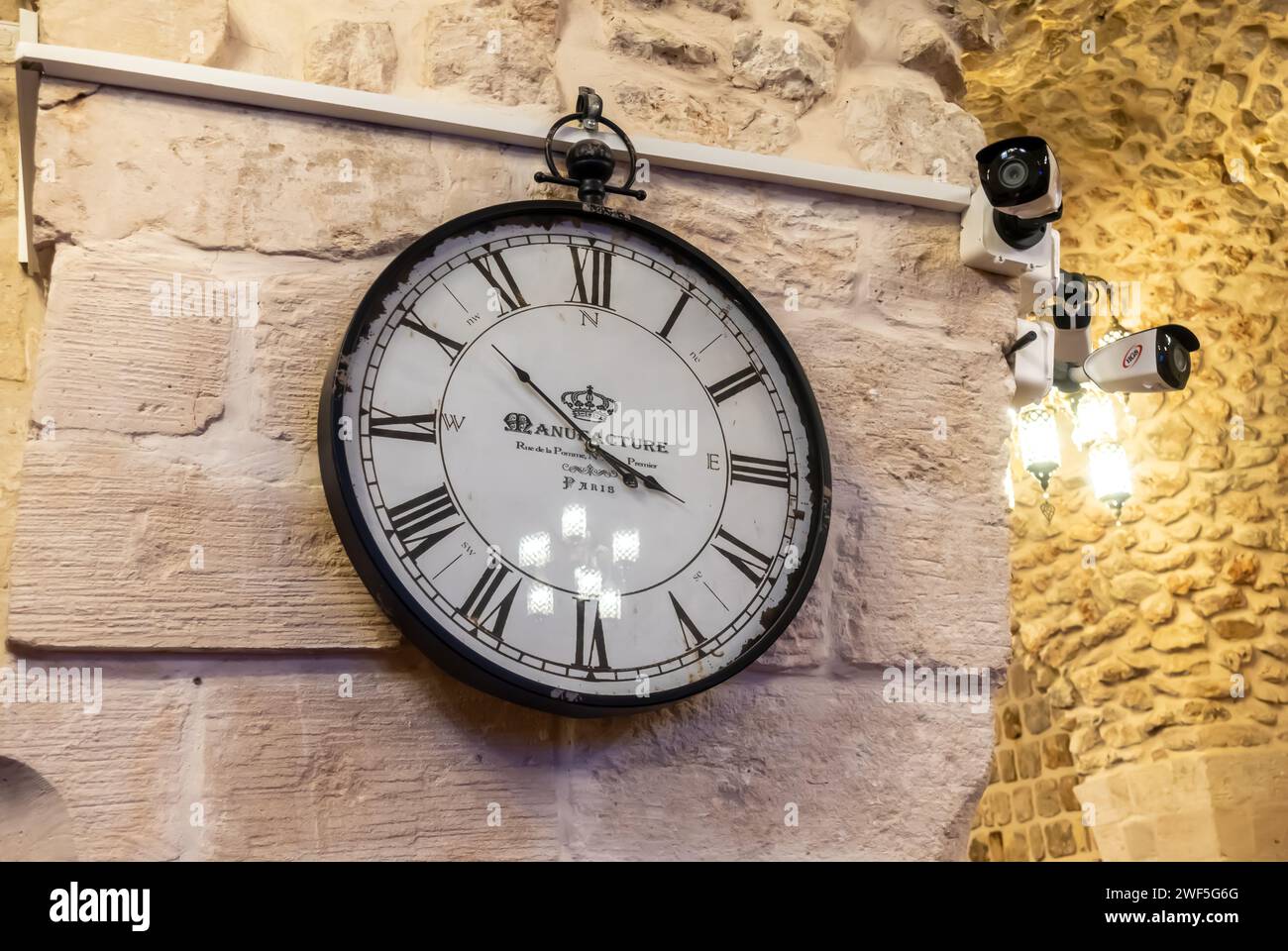 Orologio da parete - la produce parigini accanto alle telecamere DDTV nell'ambientazione del muro in un edificio storico a Mardin in Turchia Foto Stock