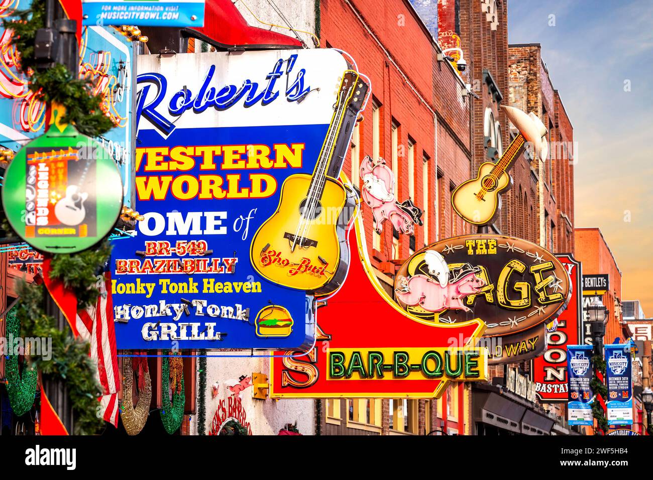 Nashville, Tennessee, USA - 24-12-2023: Famosi cartelli al neon dei club blues su Beale Street durante il giorno, nell'attrazione del centro di Nashville Foto Stock