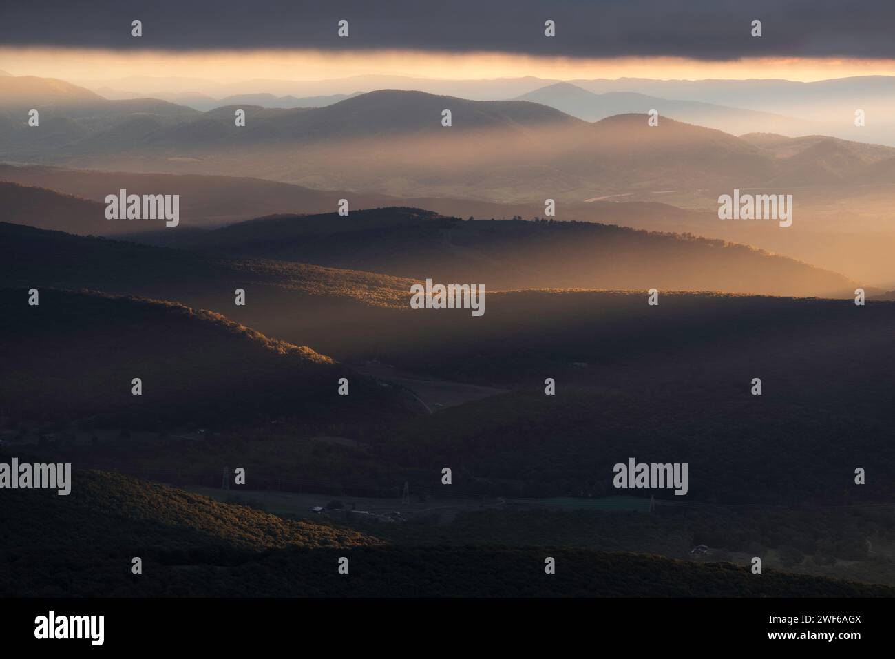 Raggi di luce riempiono le valli della Virginia Occidentale durante un'alba d'autunno sovrastata dai monti Appalachi. Foto Stock