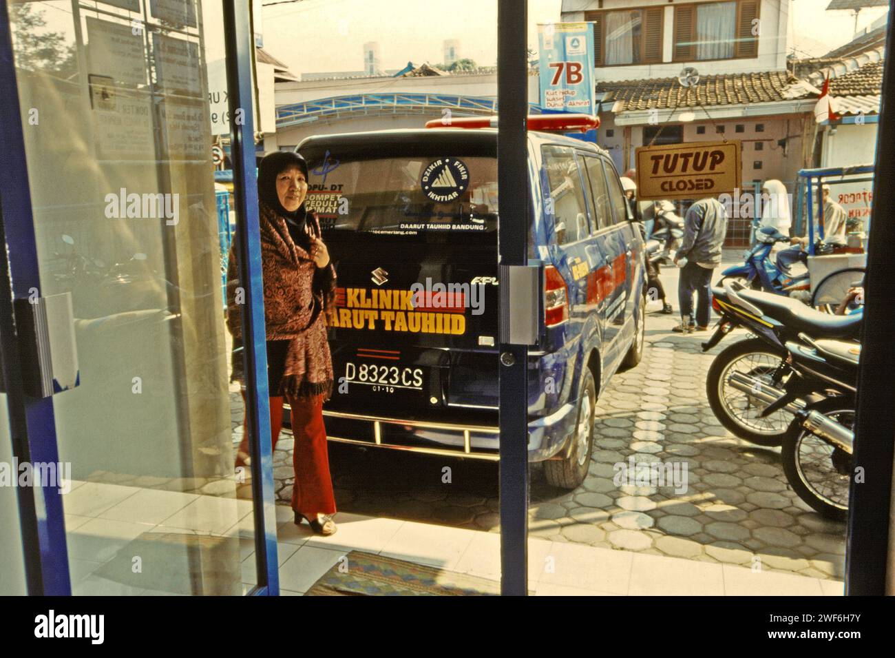 Una donna viene fotografata alla porta d'ingresso, mentre cammina per entrare nella clinica gestita dalla fondazione Daarut Tauhiid a Bandung, Giava Occidentale, Indonesia. Costruito da un famoso predicatore islamico indonesiano KH Abdullah Gymnastiar, da un collegio e da una fondazione Daarut Tauhiid, insieme al suo marchio di attività Manajemen Qolbu (mq), sono riusciti a intensificare il turismo religioso e le attività economiche nell'area di Gegerkalong nella città di Bandung. Foto Stock