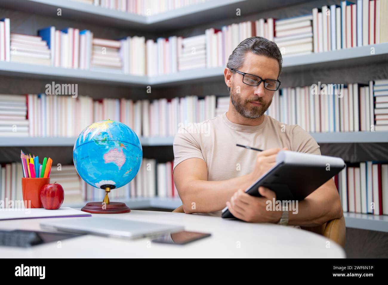 Insegnante tutor in classe scolastica. Conoscenza, istruzione. Uomo con lezioni di insegnamento di libri in classe. Esame universitario. Studia insegna al college. Educatore Foto Stock