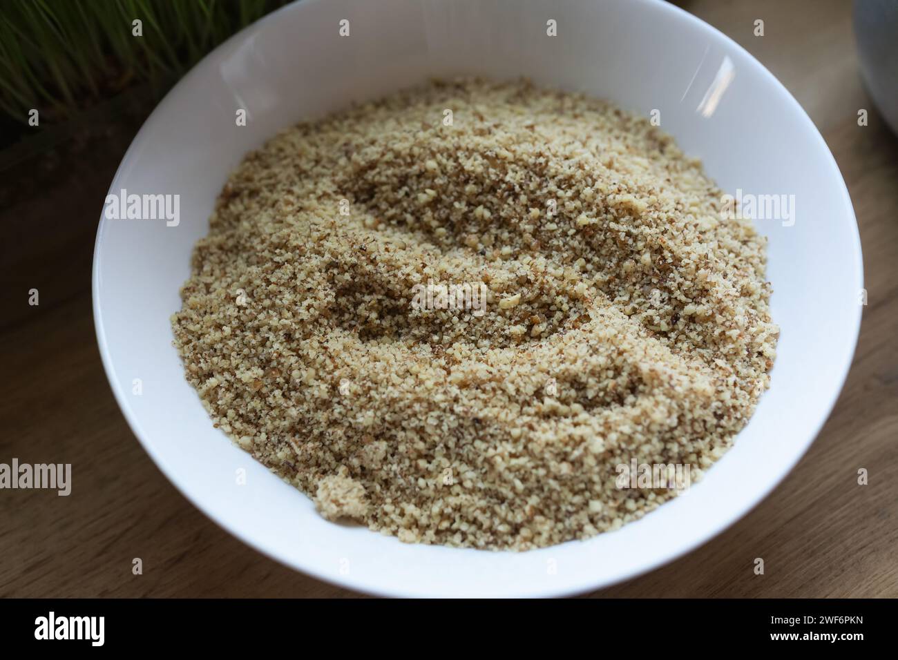 Farina di noci in un recipiente bianco sul tavolo della cucina Foto Stock