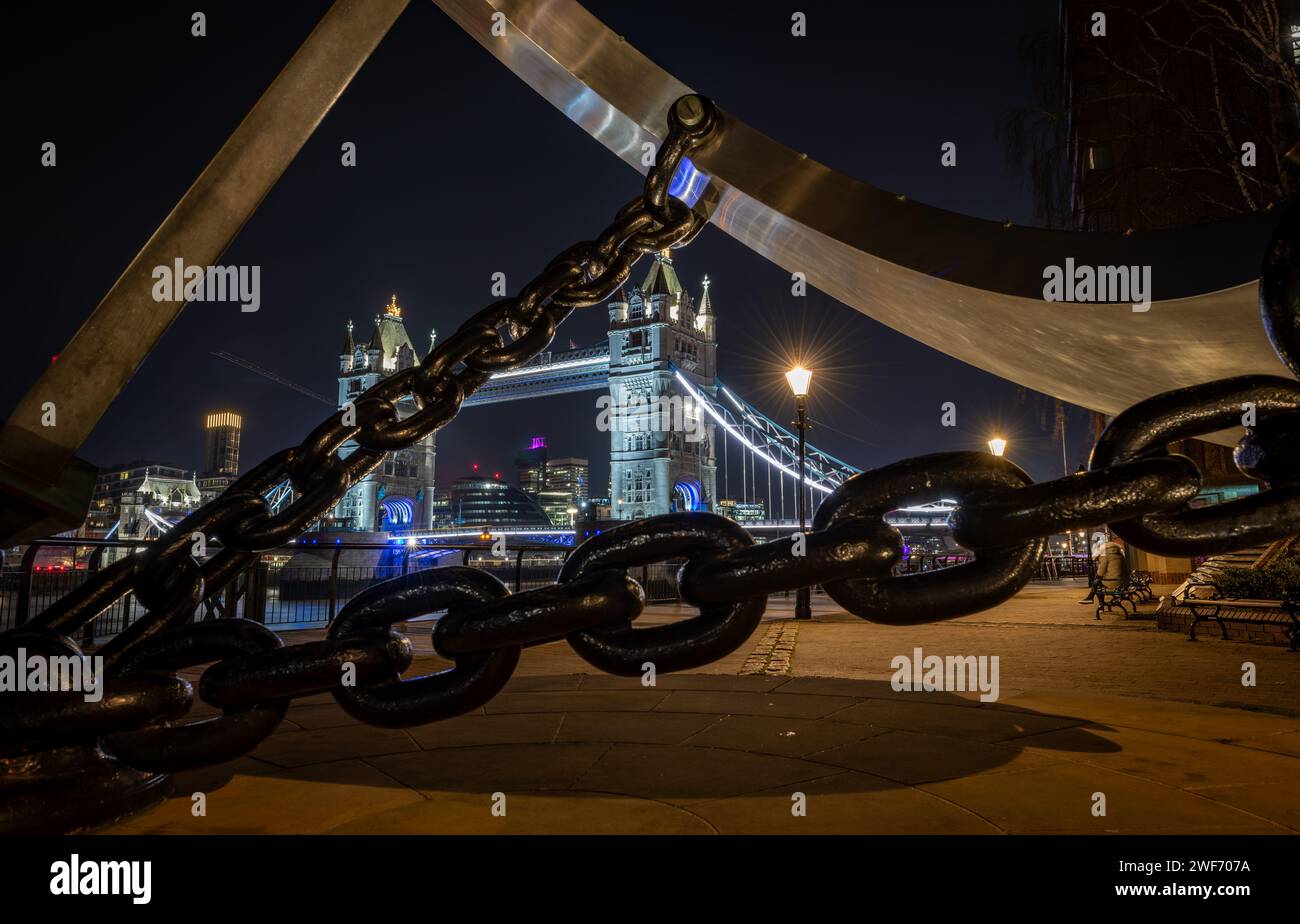 Londra. UK-01.27.2024. Una vista notturna del Tower Bridge da sotto la scultura dell'orologio Sundial. Foto Stock