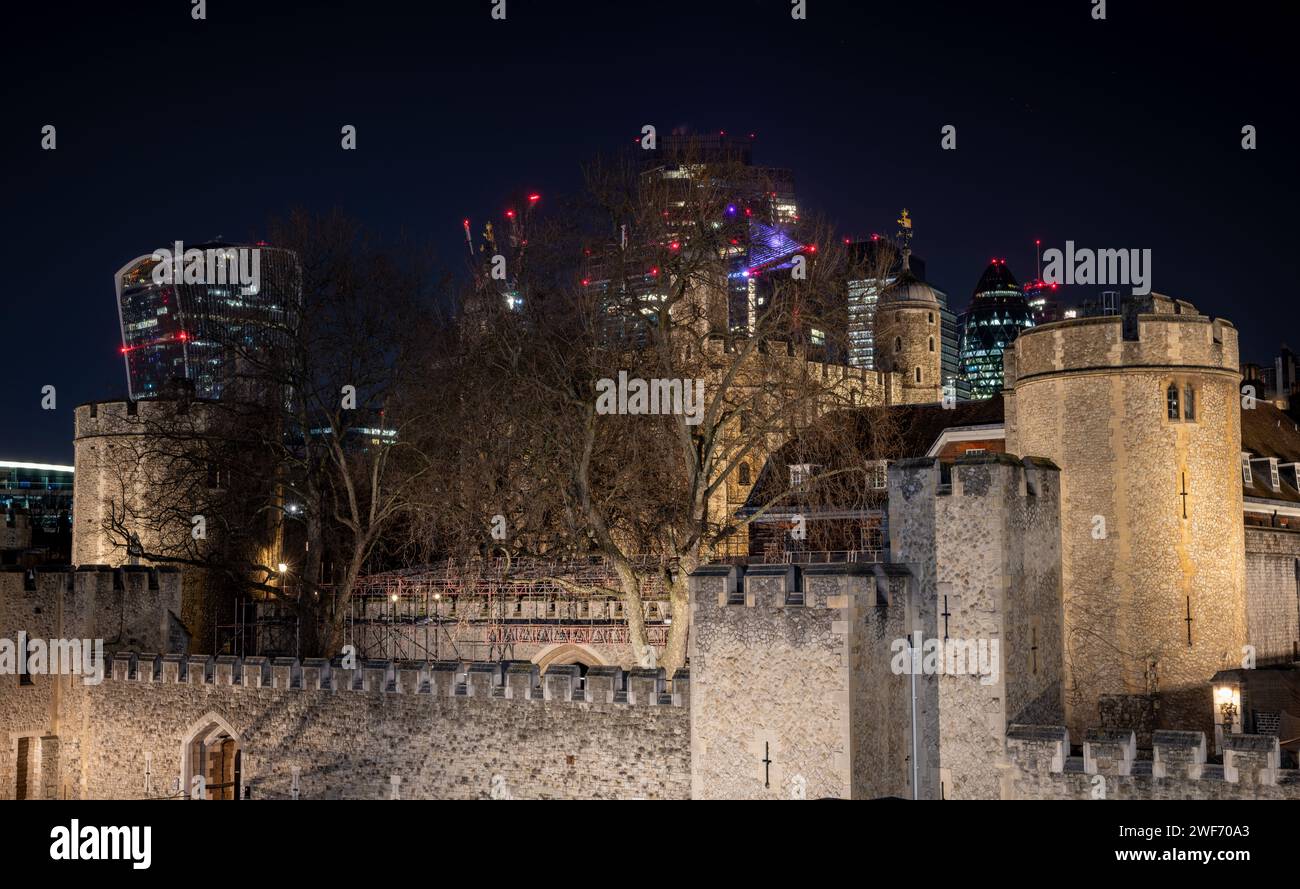 Una vista notturna della Torre di Londra con i grattacieli della City di Londra sullo sfondo. Foto Stock