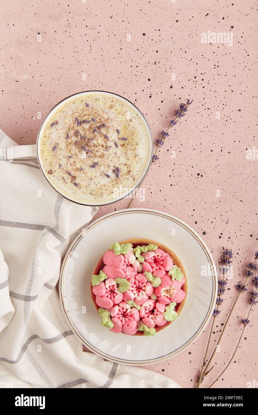 Colazione con caffè alla lavanda con fiori e dessert floreale da vicino. Estetica estiva. Foto Stock