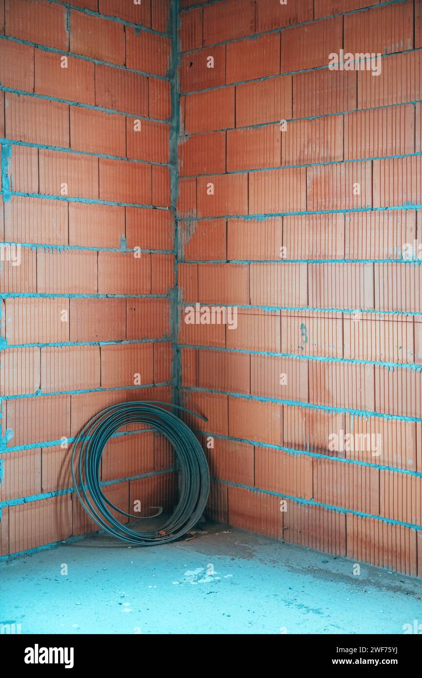 Rotolo di acciaio piatto in cantiere con pareti in blocchi di argilla termica, spazio per le copie incluso Foto Stock