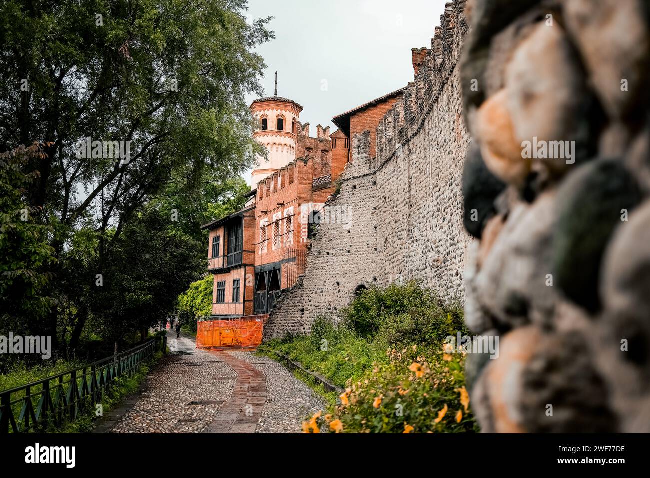 Un tranquillo sentiero che conduce all'incantevole Borgo medievale, immerso nel verde lussureggiante del Parco del Valentino a Torino, Italia. Foto Stock