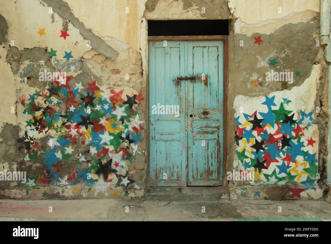 Porta blu e parete ricoperta di arte Foto Stock