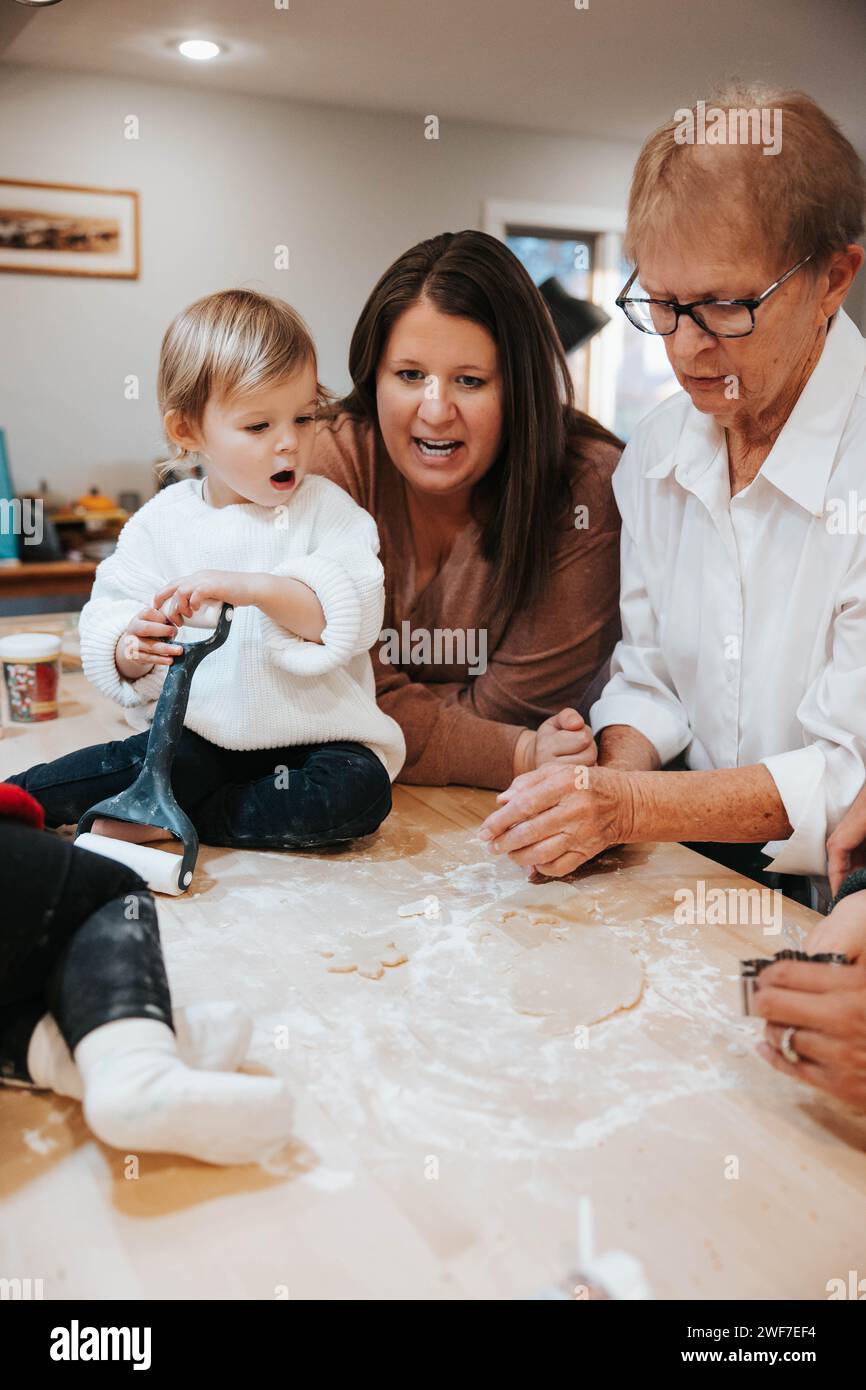Tre generazioni hanno tagliato i biscotti allo zucchero, delizie in cucina Foto Stock
