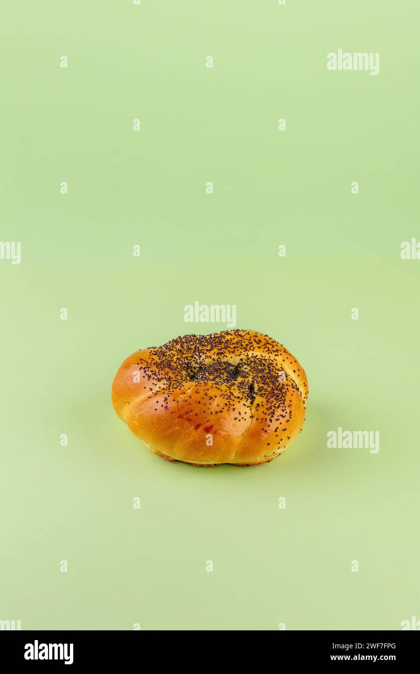 un panino con semi di papavero su sfondo colorato Foto Stock