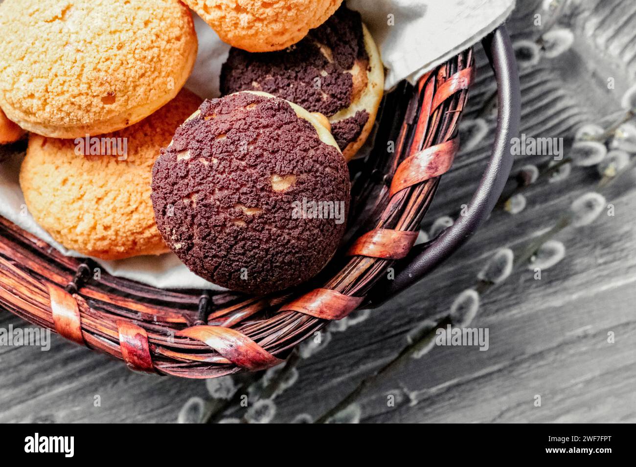 Colpo sopra la testa di un choux di eclair in un cestino di vimini Foto Stock