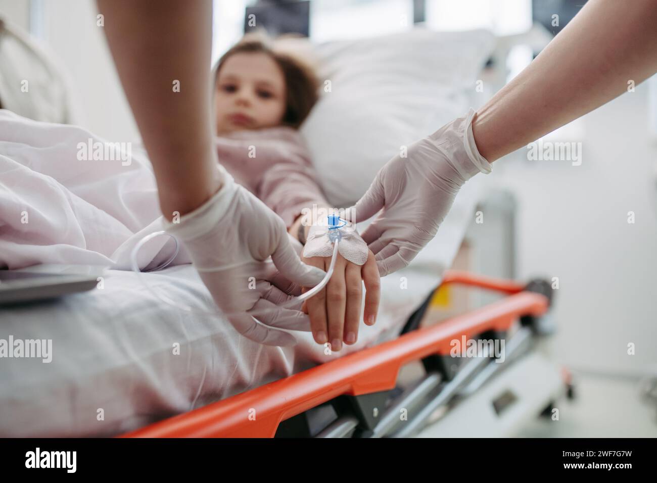 Primo piano dell'infermiera che inserisce la cannula IV nella mano di una bambina. IV, terapia endovenosa per pazienti pediatrici. Foto Stock