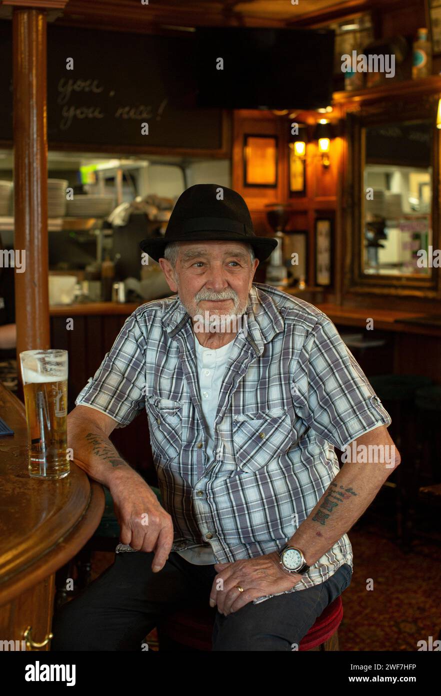 Uomo di mezza età di bere una pinta di birra da solo in un pub Foto Stock