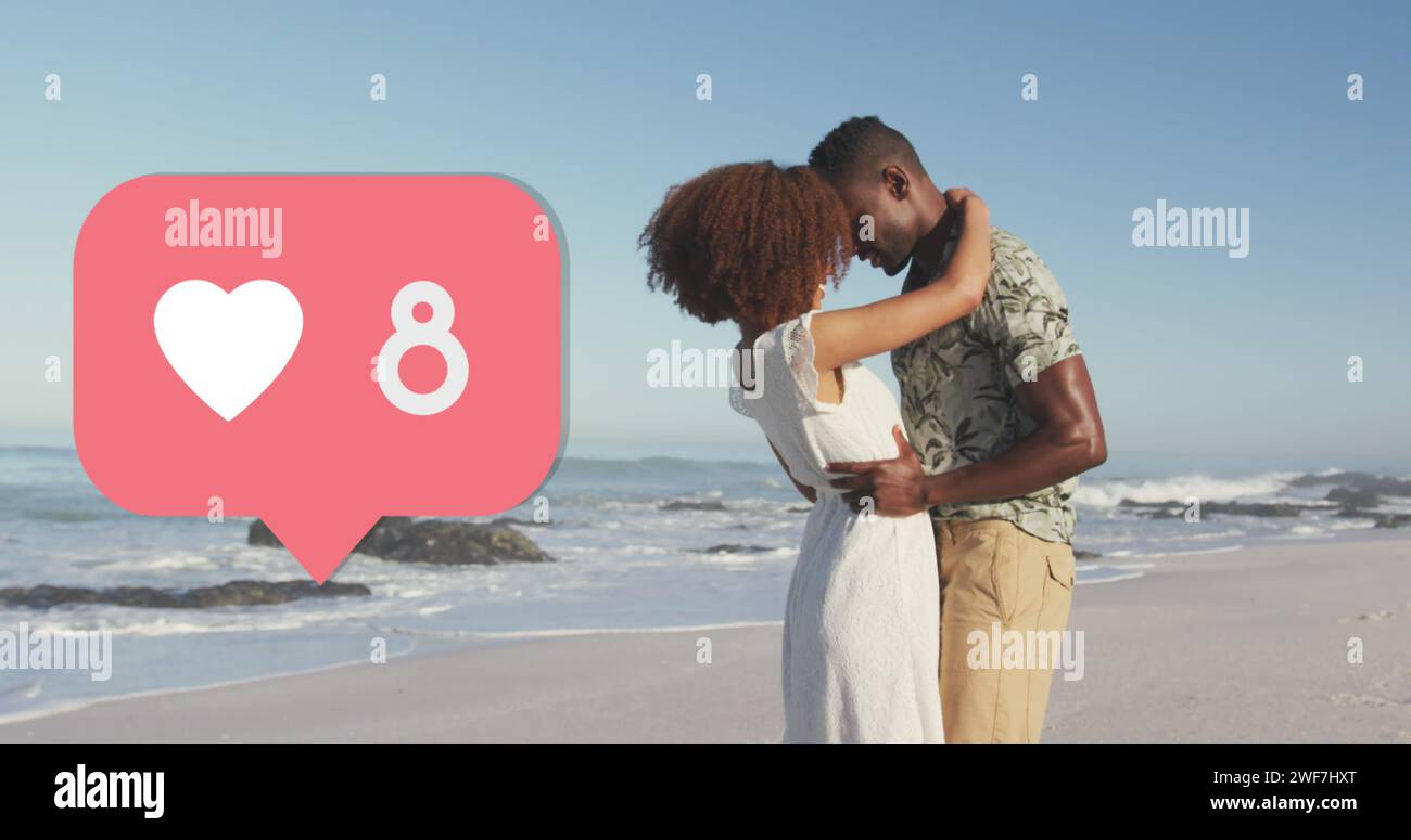 Icona del cuore con un numero crescente di persone contro coppie afro-americane che si abbracciano a vicenda sulla spiaggia Foto Stock