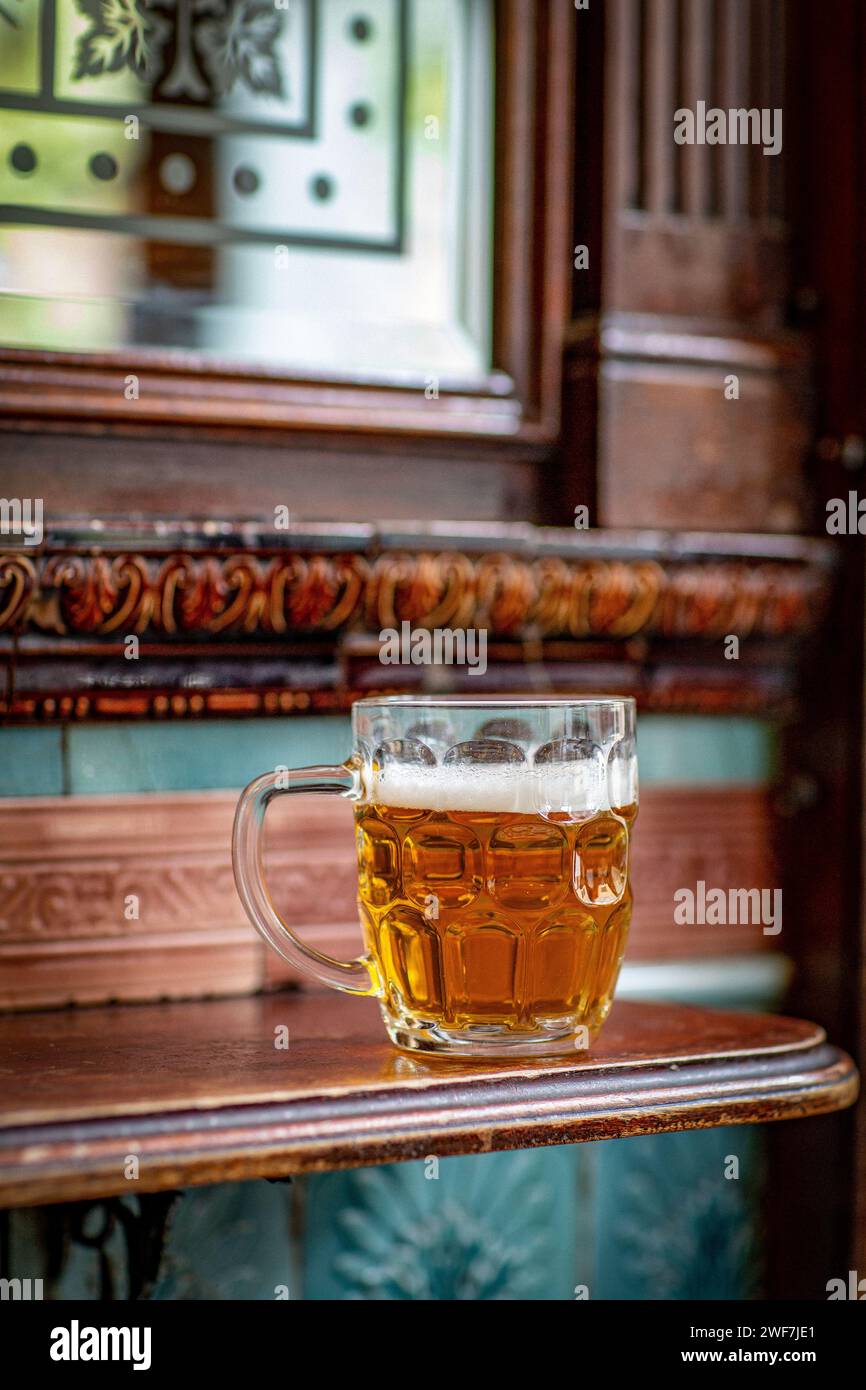 Tazza da pinta inglese con birra in piedi sul tavolo nel pub Foto Stock