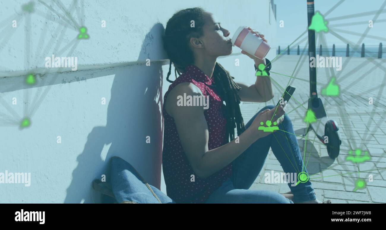 Immagine di una rete di connessioni con icone tecnologiche sopra la donna seduta sul lungomare Foto Stock