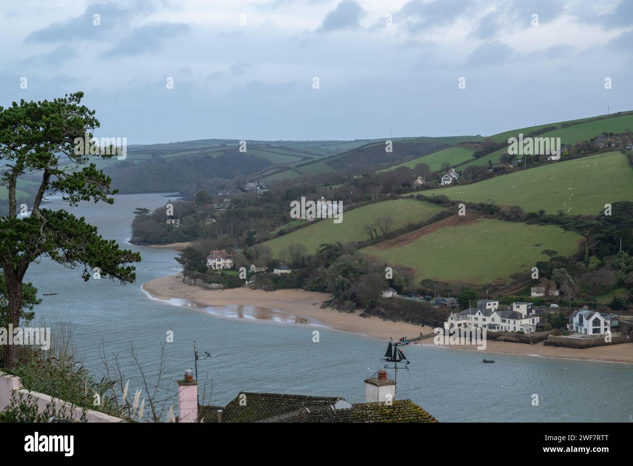 Vista lungo l'estuario di Salcombe verso la città di Salcombe dal sentiero pubblico che corre parallelo a Cliff Road, durante la bassa marea in una tranquilla giornata invernale. Foto Stock