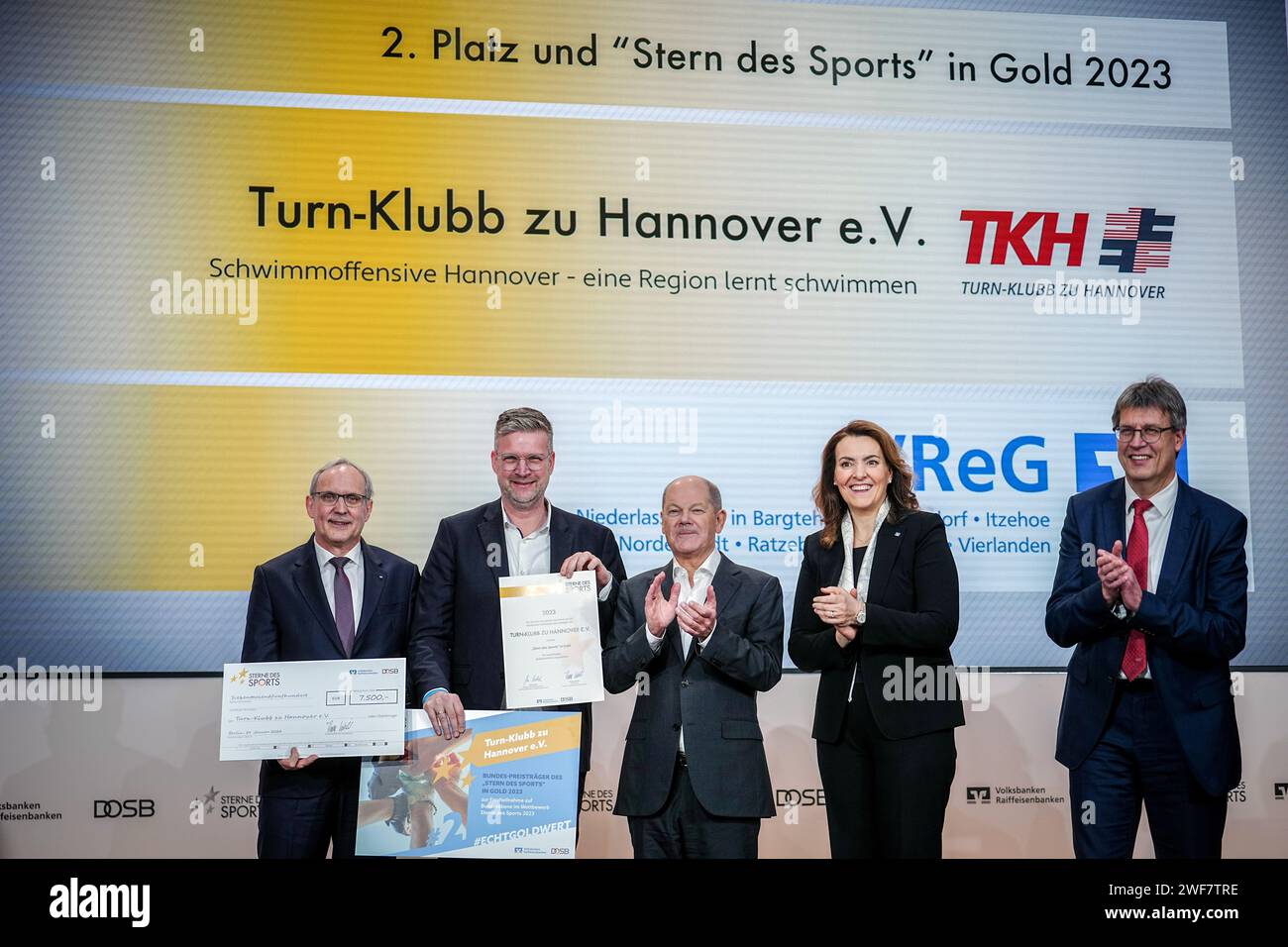 29 gennaio 2024, Berlino: il Cancelliere federale Olaf Scholz (SPD, M) insieme a Thomas Weikert (r), presidente della Confederazione sportiva olimpica tedesca (DOSB) e Marija Kolak (2° da destra), presidente dell'Associazione federale delle banche cooperative tedesche (BVR), assegnando il 2° posto a "Turn-Klubb Hannover" alla cerimonia d'oro "Sterne des Sports". La competizione per club "Sterne des Sports" è un'iniziativa del DOSB e del Volksbanken Raiffeisenbanken in Germania. Riconosce le società sportive che dimostrano impegno sociale attraverso il loro lavoro volontario al di là della legge sportiva Foto Stock