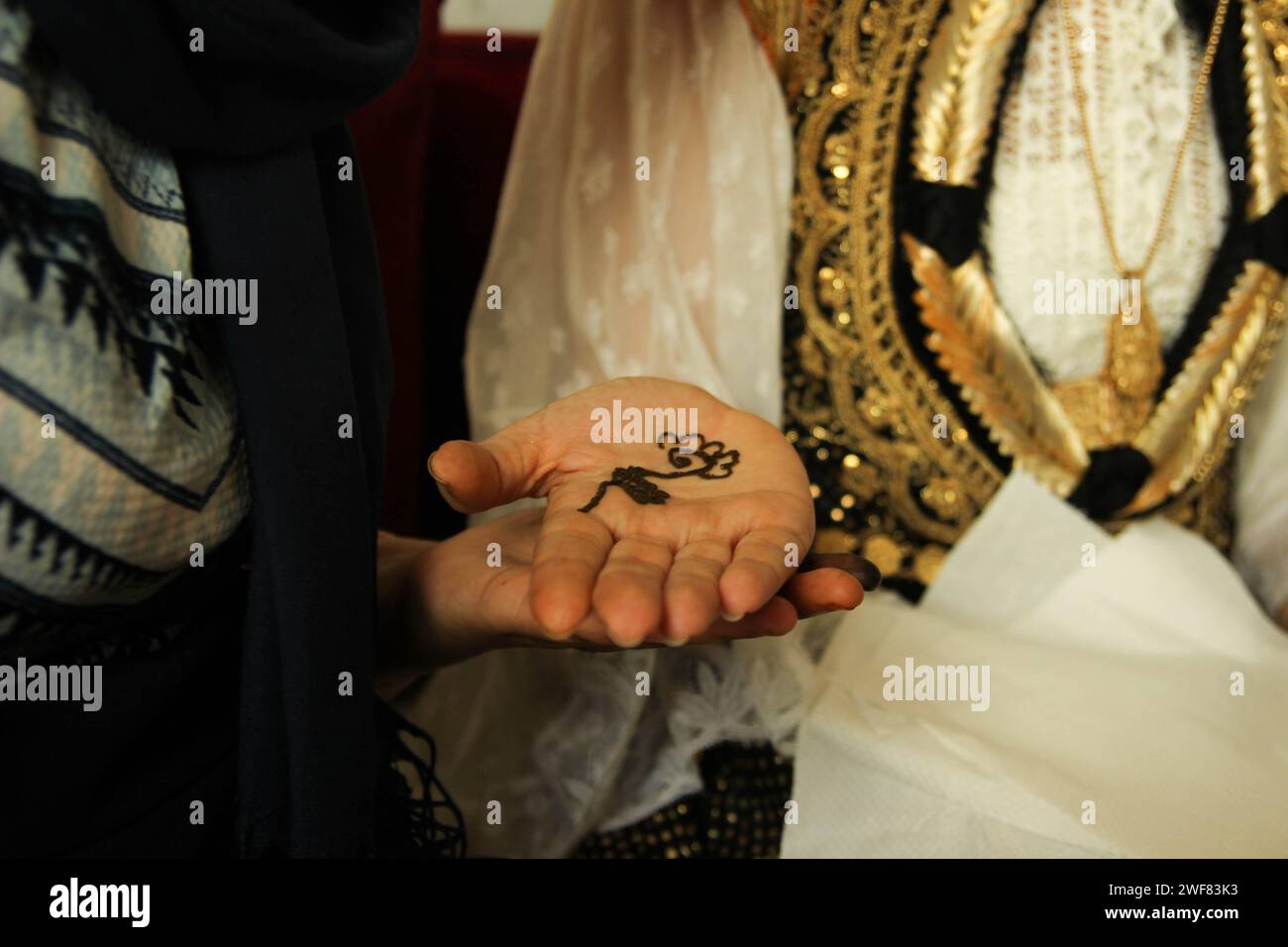 Tatuaggio all'henné con fiori sulla palma della sposa araba Foto Stock