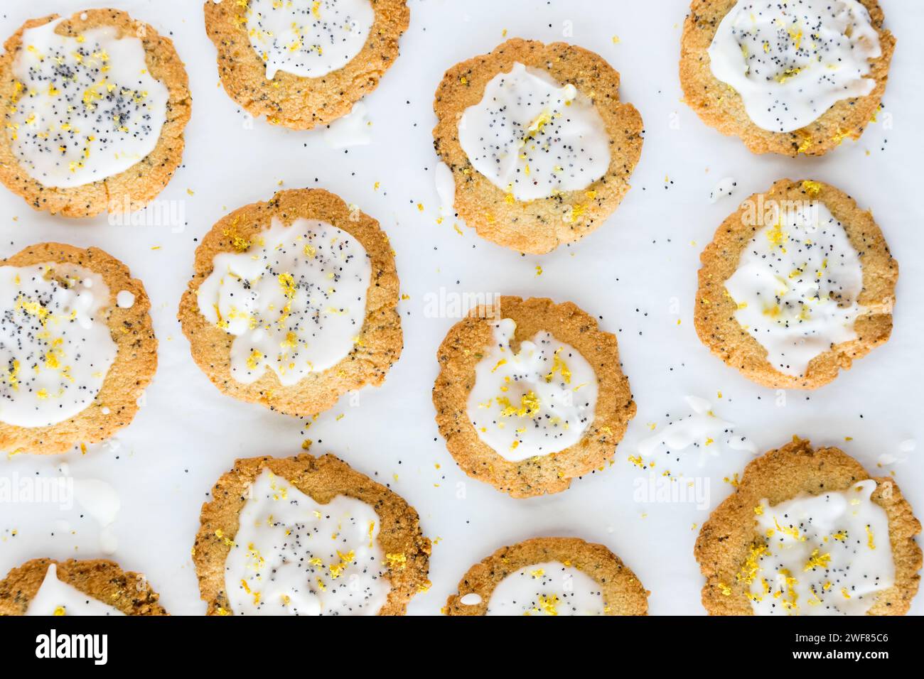 Vista dall'alto verso il basso dei biscotti fatti in casa a base di semi di limone su carta pergamena bianca. Foto Stock