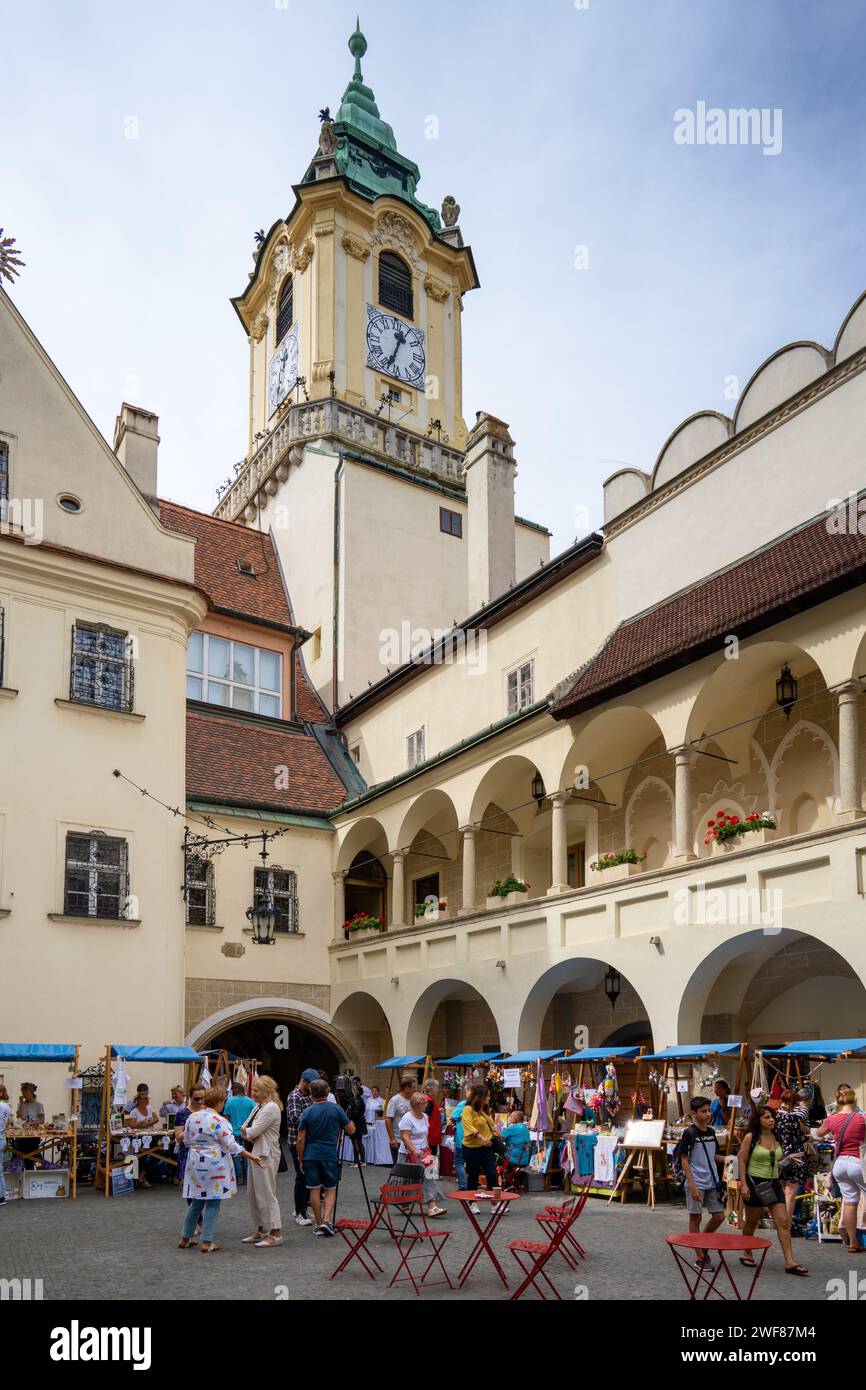 Un vivace mercato locale nel cortile rinascimentale storico del Municipio Vecchio di Bratislava, Slovacchia, con l'iconica torre dell'orologio. Foto Stock
