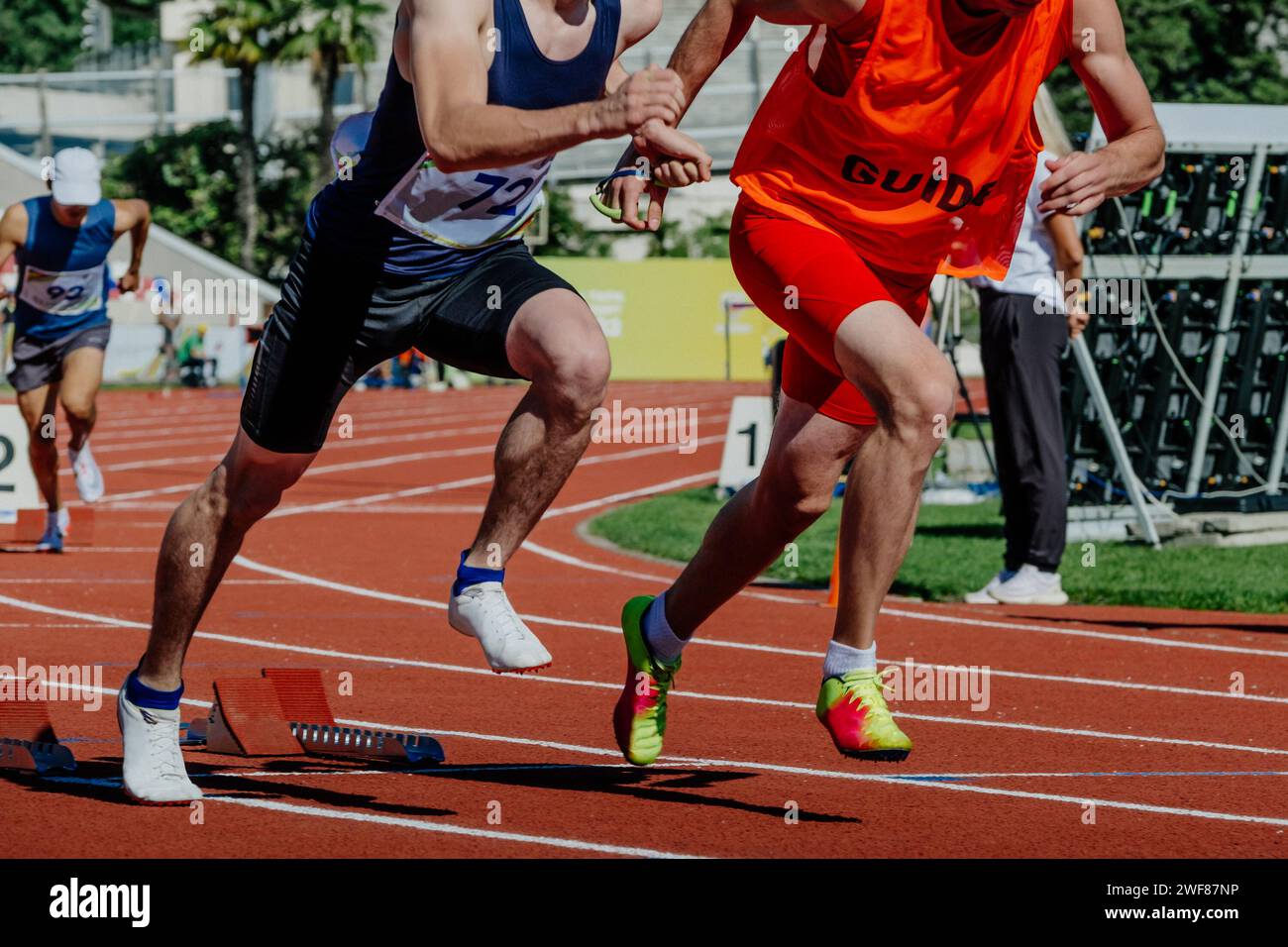 atleta cieco para runner con guida nella corsa blocchi di partenza, campionati estivi di atletica para Foto Stock